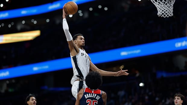 San Antonio Spurs rookie Victor Wembanyama attempts to dunk over Washington Wizards forward Marvin Bagley III.